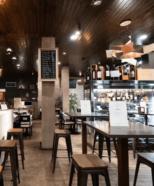 Interior del restaurante en Gijón El Feudo con zona de vinatería y mesas